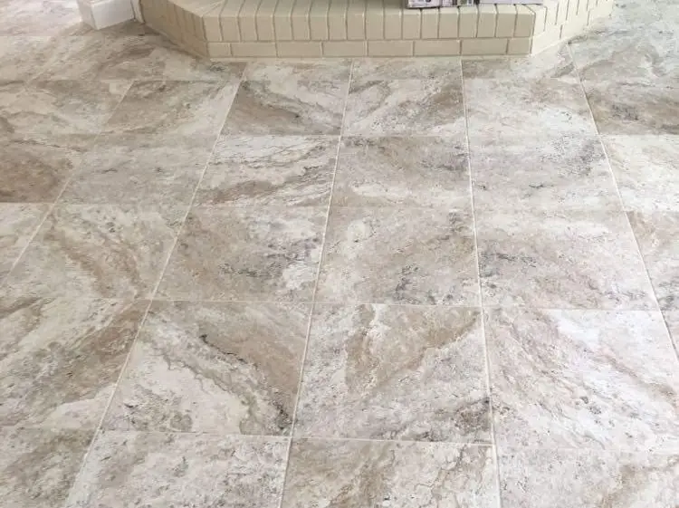a floor laid with 18 by 18 inch beige and white swirled ceramic tile on a stacked pattern